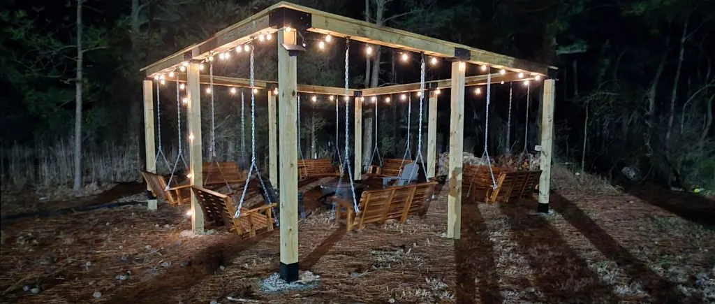 The lighted pergola at night at The Bayside Escape, a gathering spot for firefly evenings under dark skies