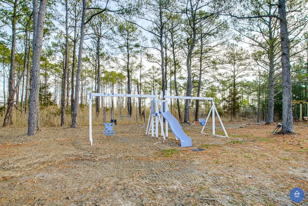 Family gathering in the backyard with the playset and pergola visible