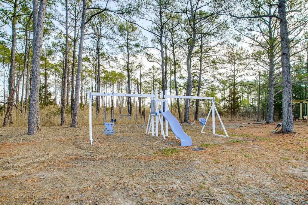 The backyard with a playset at The Bayside Escape