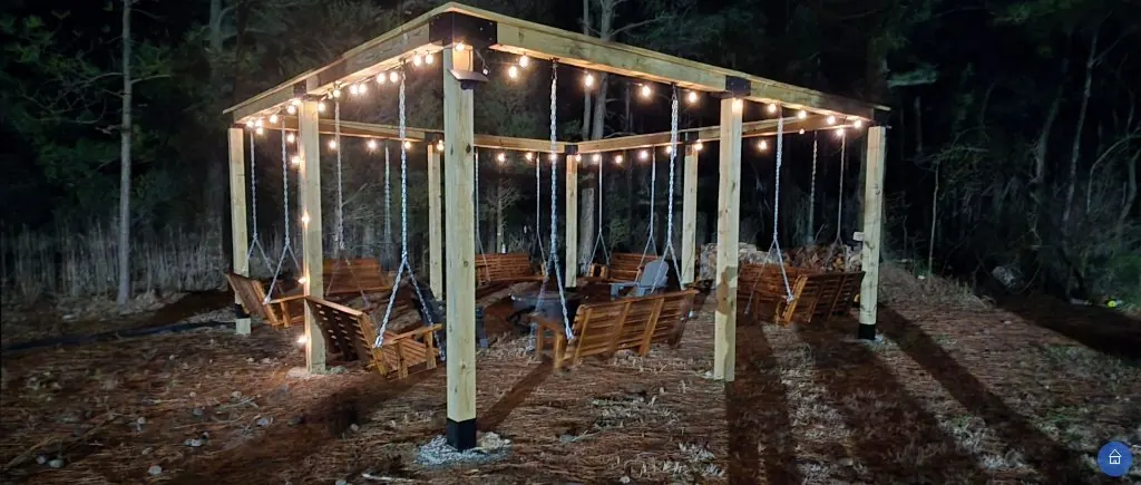 Family group under the lighted pergola at dusk — golden light